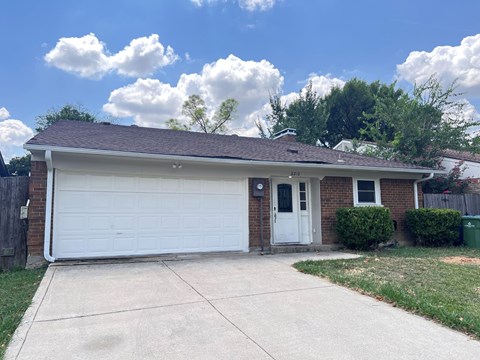 A house with a white garage door and a brown roof.